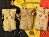 three tan canvas backpacks sitting on top of a red and yellow blanket