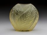 un vase en verre jaune orné d'un motif de feuilles