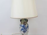 an image of a table lamp with a blue and white vase on it