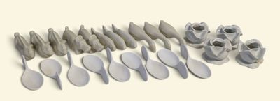 de nombreuses cuillères et spatules alignées sur une surface blanche