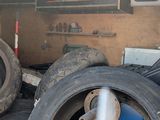 many tires stacked up in the back of a truck