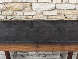 a small table with a black granite top on a wooden stand