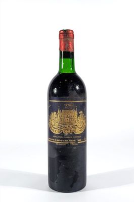 une vieille bouteille de vin posée sur une surface blanche