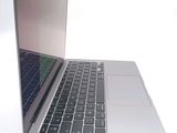 a silver laptop with a black keyboard on a white surface