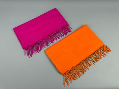 des écharpes orange et roses à franges sur un fond gris