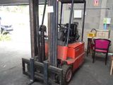 a red forklift truck parked in a garage