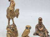trois figurines en bronze représentant des oiseaux et un homme assis sur un rocher