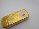 un lingot d'or muni d'une étiquette de prix, posé sur une table