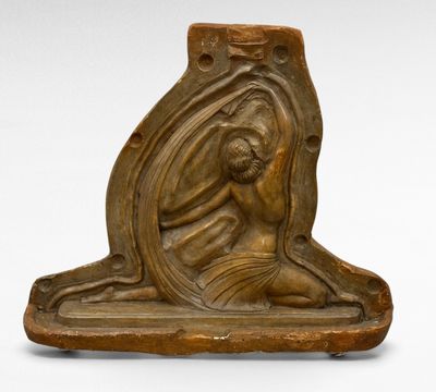 une photo représentant une statue d'une femme assise sur un bloc de pierre