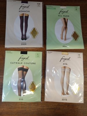 quatre paires de bas moulants exposées sur une table en bois