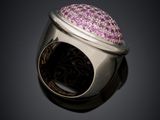an image of a silver ring with pink stones on a black background