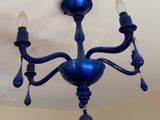 a blue chandelier hanging from the ceiling in a room