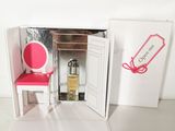 une chaise rose devant une porte devant laquelle se trouve une chaise rose