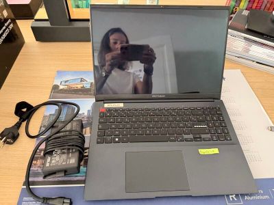 un ordinateur portable posé sur un bureau, à côté d'un téléphone portable
