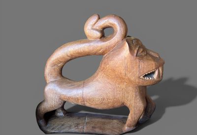 une sculpture en bois représentant un singe, posée sur un socle
