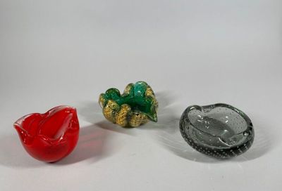 three small glass objects sitting on a white surface