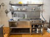 une cuisine en acier inoxydable avec un évier et une cuisinière