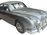 a silver car that is parked on a white surface