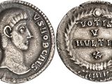 a silver coin with an image of a woman on it