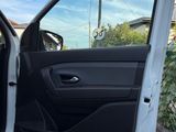 the door of a white car is open on the side of the road