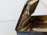 a small metal box with a lid on a table