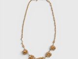 a gold necklace with flowers on a gold chain