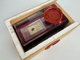 un cachet de cire dans une boîte sur laquelle est apposé un tampon à cire