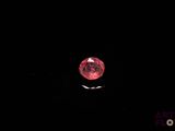 a close up of a red diamond on a black background