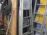 une échelle appuyée contre un mur, à côté d'un tas d'outils