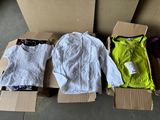 three boxes of clothing sitting on top of a floor next to each other