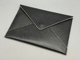 enveloppe en cuir noir avec des coutures blanches sur le dessus