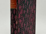 a book with a black and pink cover sitting on top of a table