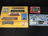 two boxed trains sitting on a table next to each other
