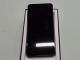 a black cell phone sitting in a box on a table