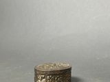 an old silver box sitting on top of a gray surface