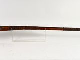 un vieux fusil avec un canon en bois sur fond blanc