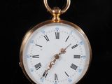 une montre de poche en or avec des chiffres romains sur le cadran