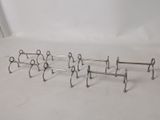 four metal racks that are lined up on a white surface