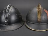 pair of antique helmets on a black background with a gold accent
