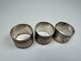 three silver cups sitting next to each other on a white surface