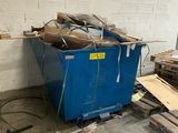 a blue dumpster in the middle of a room filled with wood