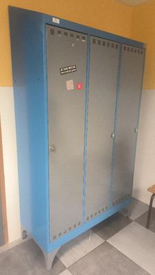 a locker in the corner of a room with a table and chair