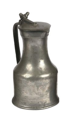 a silver pitcher with a bird on top of it