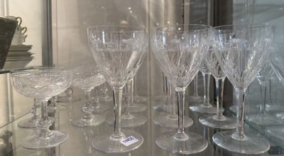 many wine glasses that are on a glass shelf