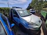 a small silver van parked next to a blue truck