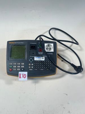 une calculatrice reliée à un cordon, posée sur une table
