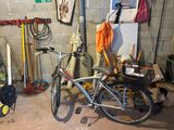 a bike that is parked in a garage next to a surfboard