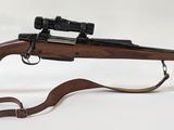 un fusil posé sur un support, avec un serpent à côté
