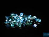 un gros plan sur un tas de diamants bleus posés sur une surface noire