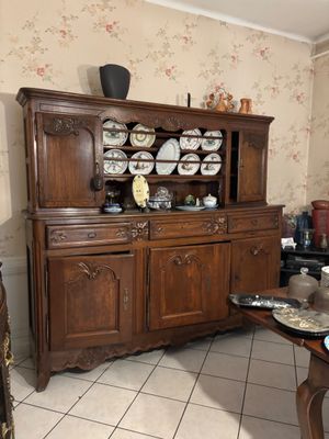 a wooden china cabinet in the corner of a room